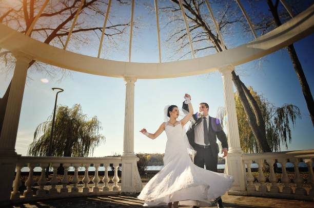 istock lovely just married couple under white arch on sunshine 669888172