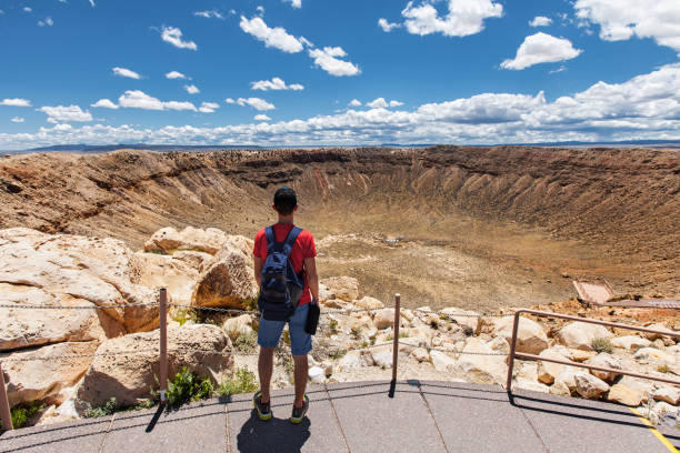 путешествие в кратер метеор, человек турист с рюкзаком наслаждаясь видом, уинслоу, аризона, сша - crater стоковые фото и изображения