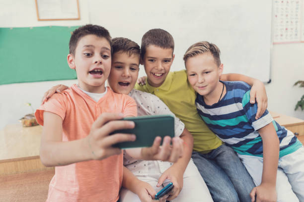istock Group of schoolboys taking selfie in the classroom. 669892954