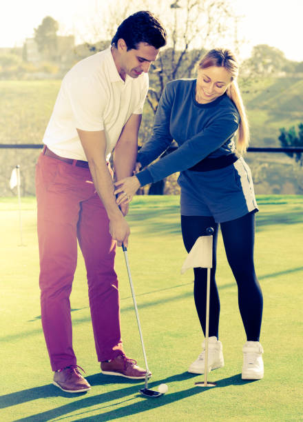 istock Woman golfer training man to play golf 669899846