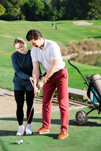 istock Female golf player  shows man  the correct hand position 669899866