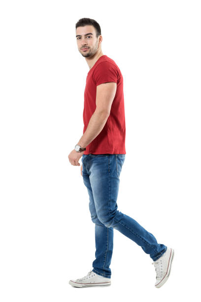 istock Side view of young relaxed casual man walking and looking at camera 669907044