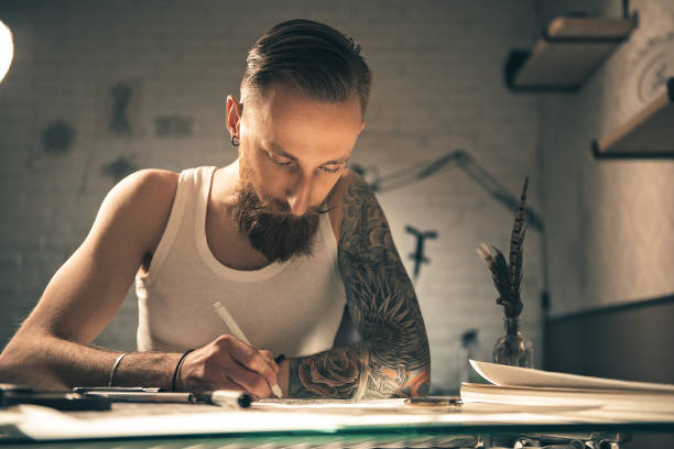 istock Serious man drawing images at desk 669907188