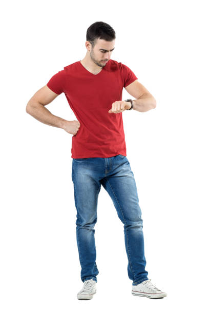Young upset casual man waiting for someone checking time on wrist watch. stock photo