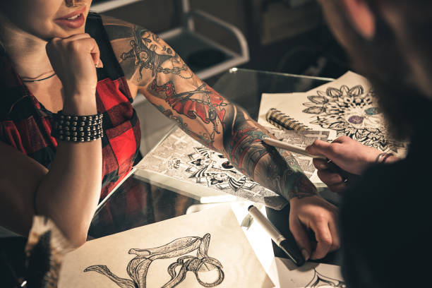 istock Female hand with tattoo situating on desk 669907914