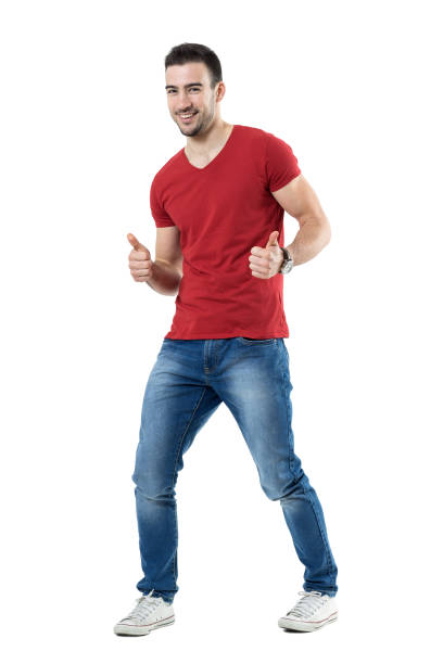 Cheerful excited young man in red t-shirt showing thumbs up gesture stock photo