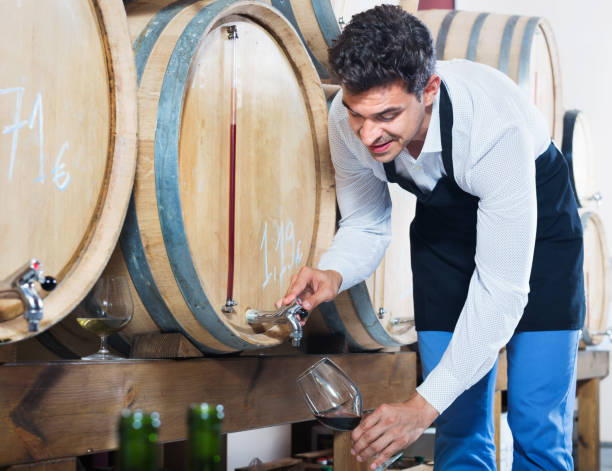 istock Man pouring red wine into glass in alcohol section 669912068