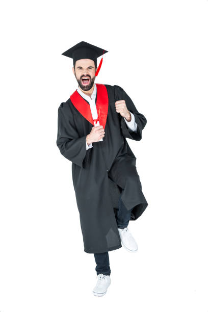 istock Excited young man in graduation hat holding diploma and triumphing on white 669922480