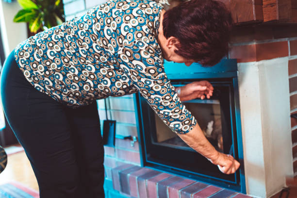 istock Senior woman at the fireplace 669923642