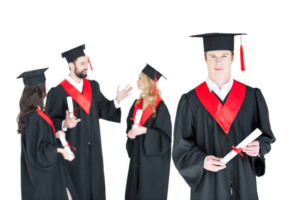 istock Young student in graduation cap with diploma and friends standing behind isolated on white 669923878