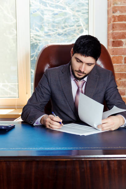 istock A young man sits at a desk in the office and working with papers. 669927378