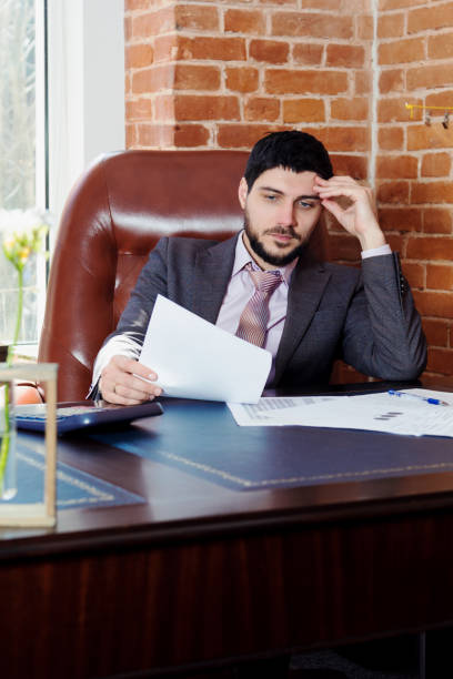 istock A young man sits at a desk in the office and working with papers. 669927562