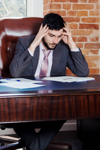 istock A young man sits at a desk in the office and working with papers. 669927630