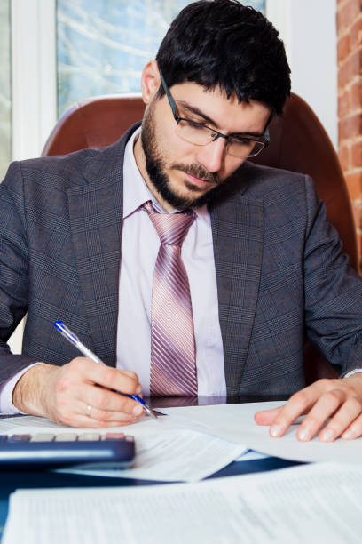 istock A young man sits at a desk in the office and working with papers. 669927700