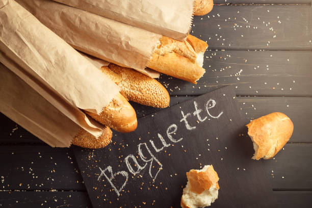French baguettes with sesame seed on black wooden background