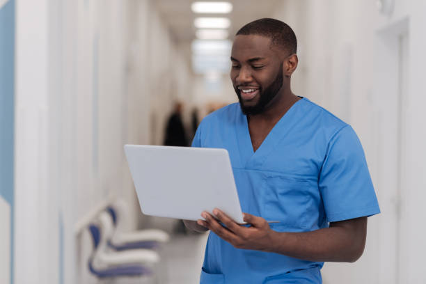 оживленный афроамериканский практикующий с помощью современного гаджета в больнице - laptop doctor using computer nurse стоковые фото и изображения
