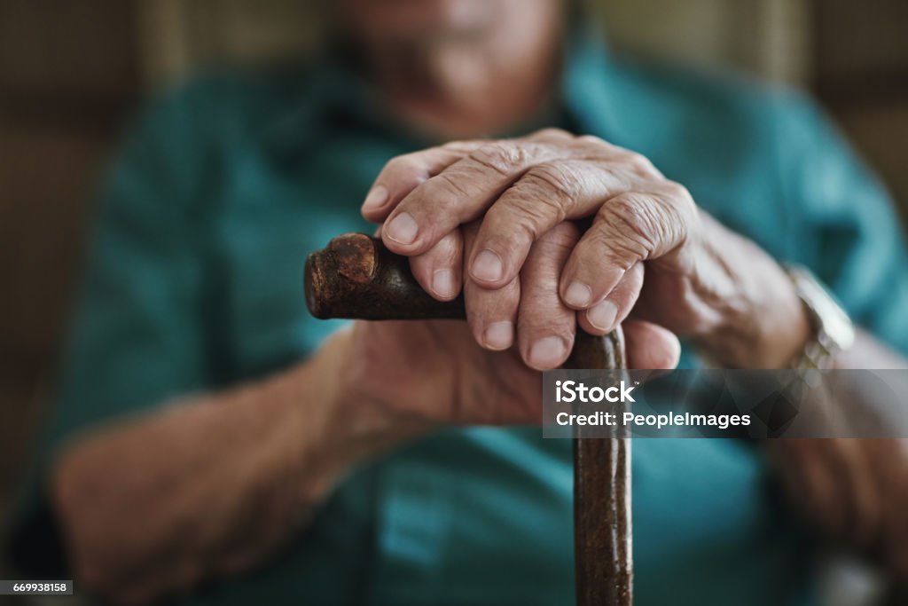 Getting older can bring senior health challenges Cropped shot of an unrecognizable man leaning on his walking stick Senior Adult Stock Photo