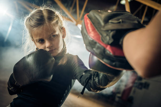 istock Little boxer having a sports training with her unrecognizable coach in a gym. 669941808