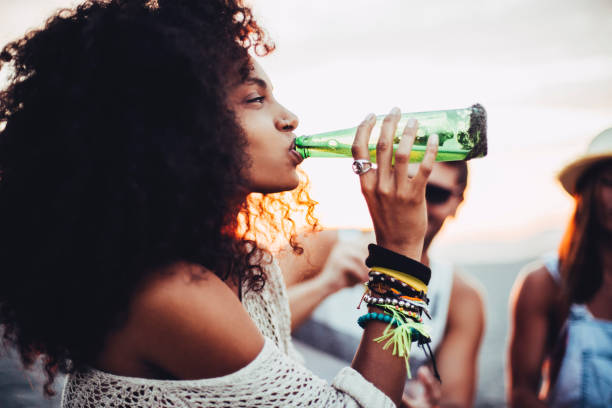 Young woman drinking beer Young woman drinking beer at the beach party. woman drinking beer stock pictures, royalty-free photos & images