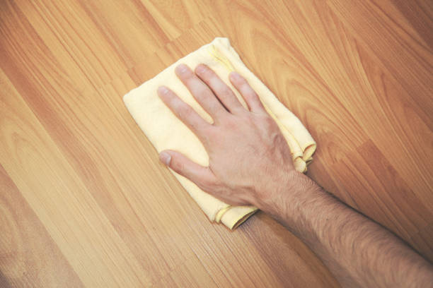 istock man  hand cleaning  an hardwood floor with a microfiber cloth. 669948072