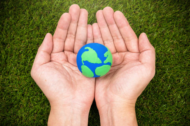 istock earth simulation in hand on grass background, earth day concept 669975928