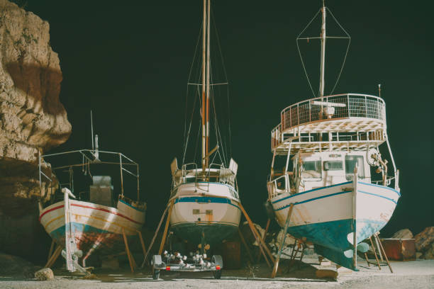 łodzie rybackie na naprawie w porcie w nocy - noway zdjęcia i obrazy z banku zdjęć