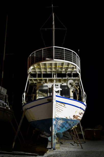 łodzie rybackie na naprawie w porcie w nocy - noway zdjęcia i obrazy z banku zdjęć