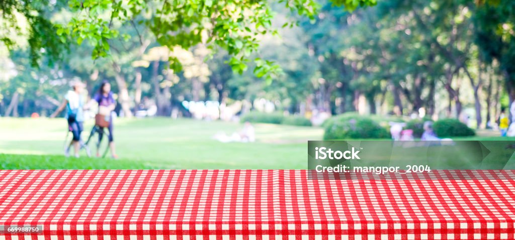 Leere Tabellenabdeckung mit roten Tischdecke über Unschärfe Park mit Menschen Hintergrund für Montage Anzeigehintergrund Produkt banner - Lizenzfrei Picknick Stock-Foto