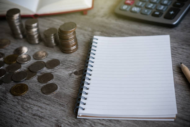 istock blank note book for writing how much thai coins after calculation on wooden background, business concept 669989550