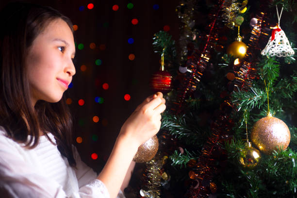 istock Young girl decorating a christmas tree 669989906