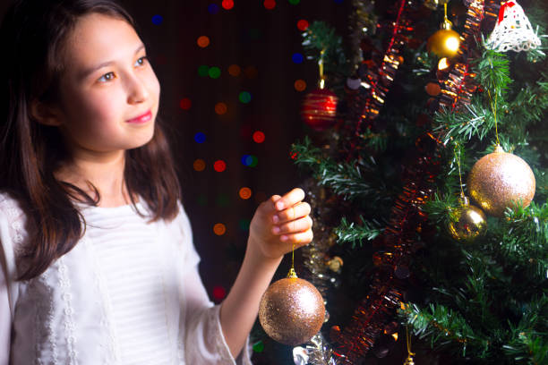 istock Young girl decorating a christmas tree 669990008