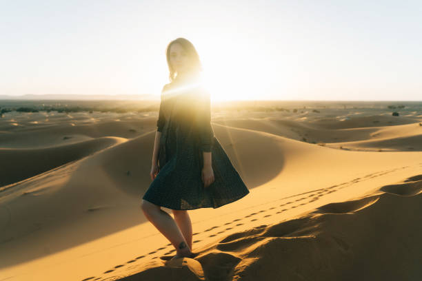 istock Woman standing on sand in the desert 669990212