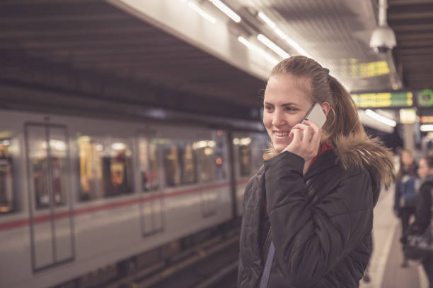 istock Young female making a call with smartphone at subway station 669992532