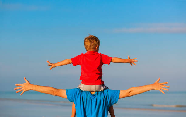 istock happy father and son playing on sea 669993652