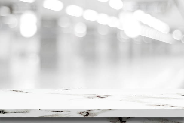istock Empty white marble table over blur store background, product and food display montage 669994322