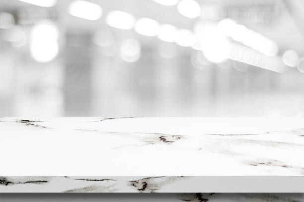 istock Empty white marble table over blur store background, product and food display montage 669994570