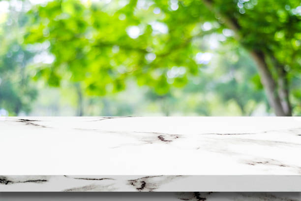 istock Empty white marble table over blur green park background, product display montage 669996212