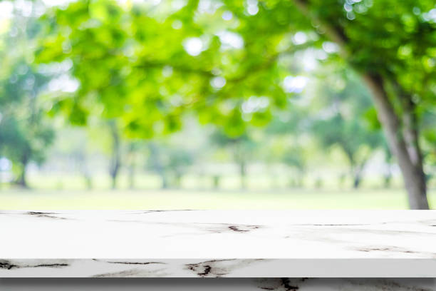 istock Empty white marble table over blur green park background, product display montage 669996214