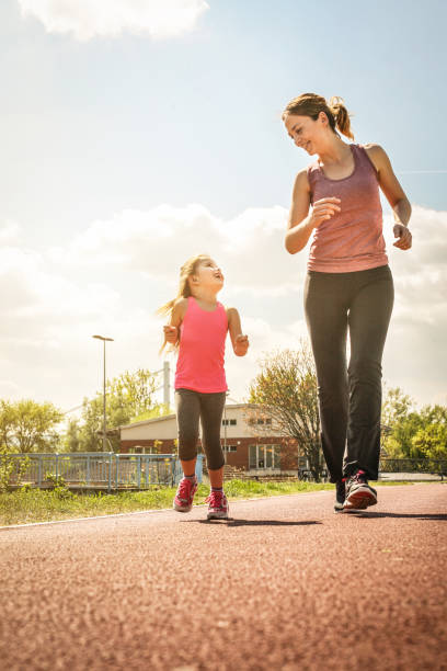 madre caucásica e hija jogging al aire libre. - family sport exercising jogging fotografías e imágenes de stock