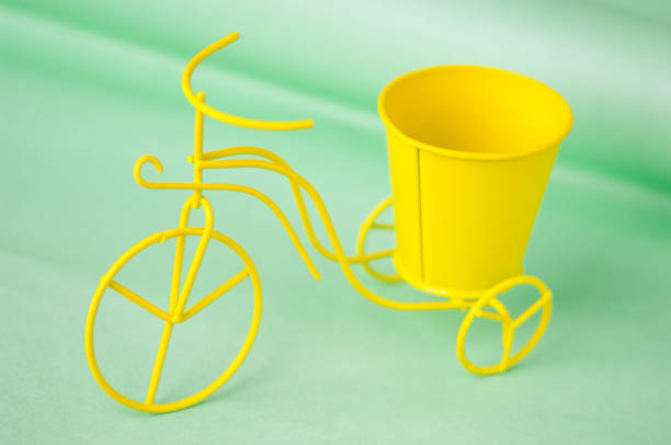 souvenir toy metallic bicycle with a bucket on a green background