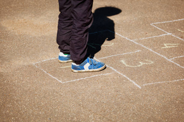 istock little boy playing hopscotch on playground 669997612