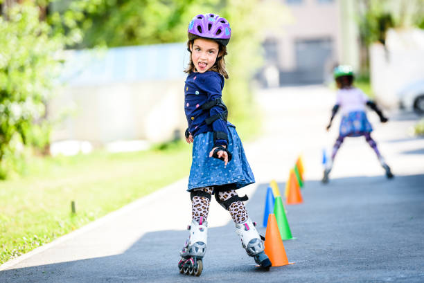 istock Children learning to roller skate on the road with cones. 669999844