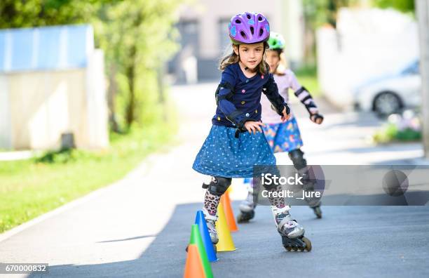 Children Learning To Roller Skate On The Road With Cones Stock Photo - Download Image Now