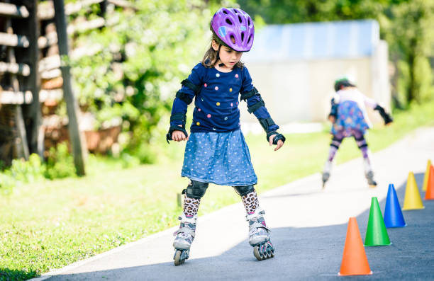 istock Children learning to roller skate on the road with cones. 670001436