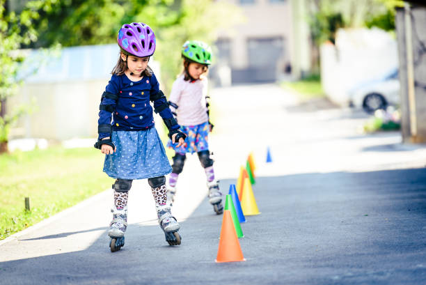 istock Children learning to roller skate on the road with cones. 670001512