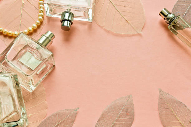 istock Female perfume on a pink background with decorative leaves 670014216