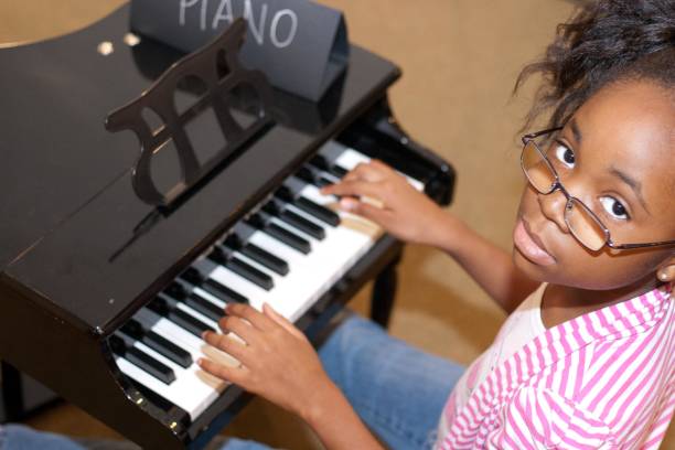 black girl playing a piano - child prodigy imagens e fotografias de stock