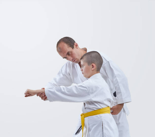 istock Karate boy teaches the coach hit a punch arm 670019878