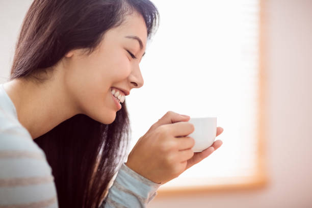 istock Asian woman relaxing on couch with coffee 670020006