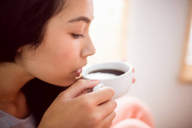 istock Asian woman relaxing on couch with coffee 670020154